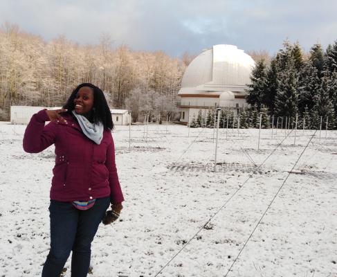 Woman poses in front of an observatory